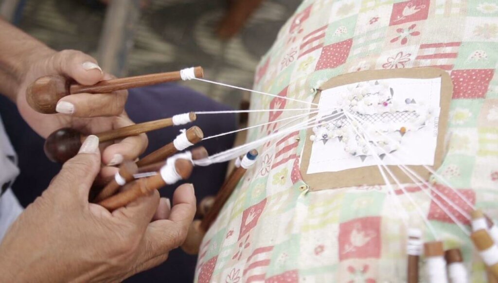 mãos bordando tecido