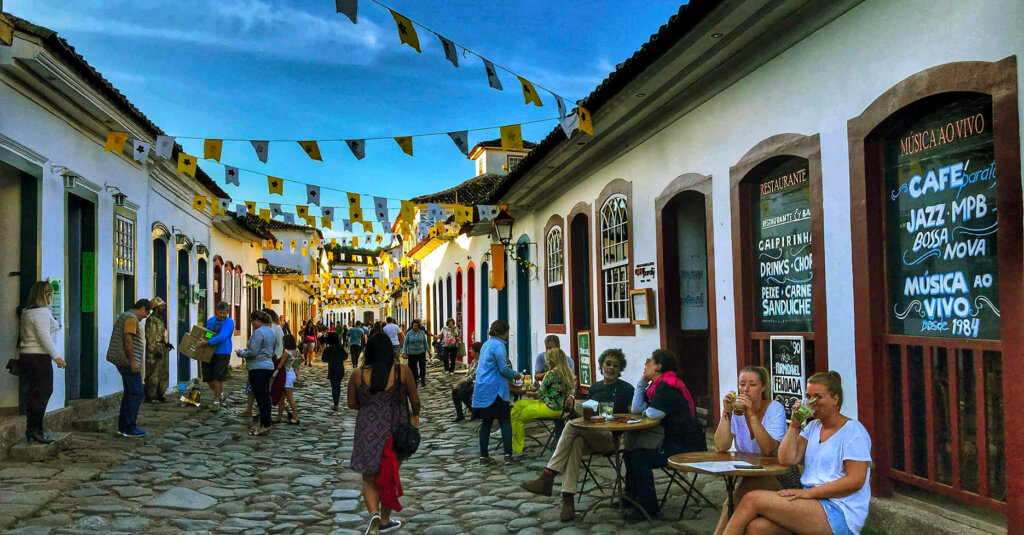 casas antigas, pessoas na rua, bandeirinhas penduradas no centro histórico de Paraty